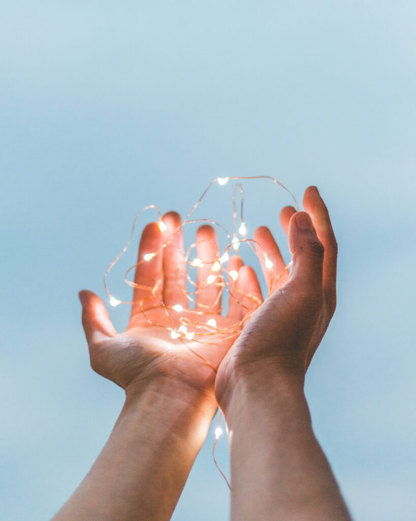 image person holding string lights